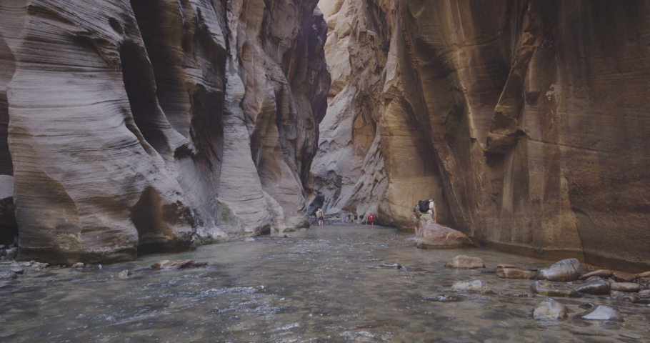Tourists walking the Narrows path in Zion park