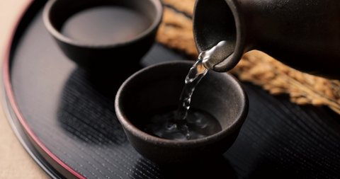Pour sake into a cup