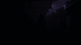 Woman dancing in a dark industrial hallway with light effects. Art motion effects. Background for music video.