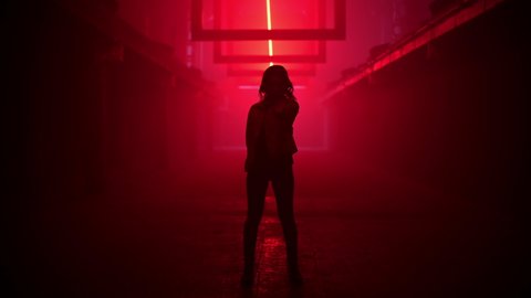Woman in a red jacket dancing in a dark tunnel with light effects. Dancing footage for music video.
