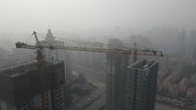 Construction site in heavy haze air pollution, downtown city building in fog. Environmental conservation, business, industry concept b-roll footage. Highly polluted air and cityscape of Shanghai China