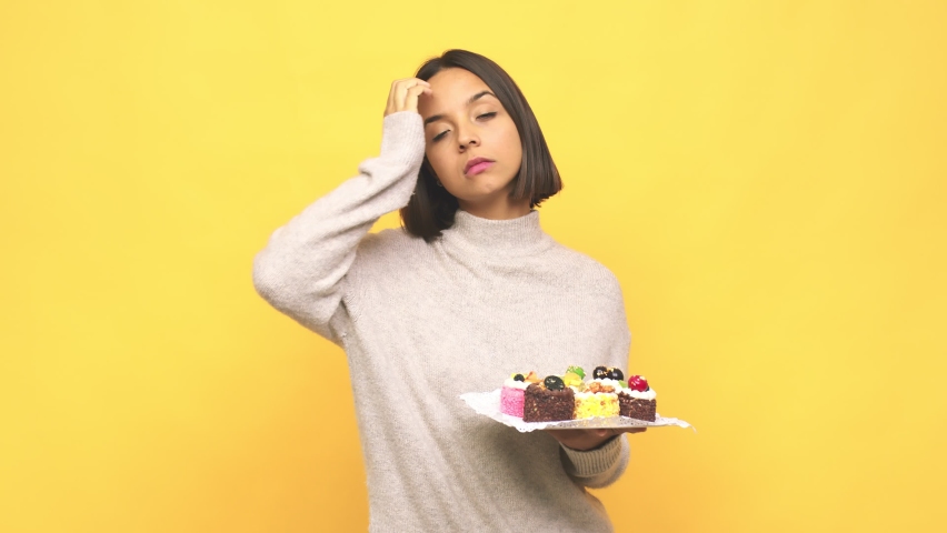 Young latin woman holding muffins being shocked, she has remembered important meeting Royalty-Free Stock Footage #1065135934