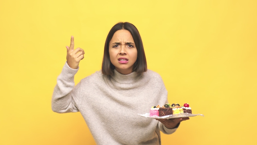 Young latin woman holding muffins showing a disappointment gesture with forefinger Royalty-Free Stock Footage #1065135940
