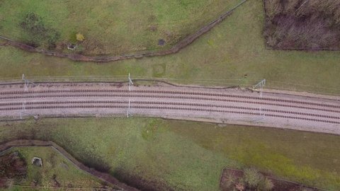 Empty railway in the forest in winter. Top view. Drone footage over rail lines. Aerial view of abandoned deserted railroad in beautiful forest.