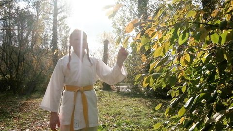 teenager girl 12 years old is engaged in karate outdoors. Healthy lifestyle concept. playing sports. martial arts. Judo, Jiujitsu. brave, strong. Walks smiling in the park. workouts