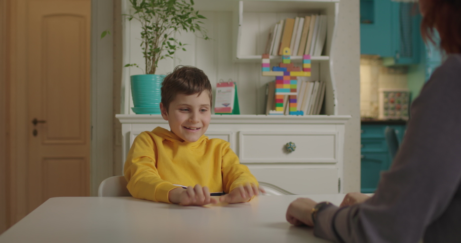 Child with autism playing finger game with therapist. School boy with autism studying with mother at home. Autistic kid learns to focus attention and coordination. Royalty-Free Stock Footage #1065150664