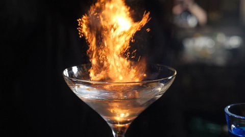 Bartender threw cinnamon powder to flame a cocktail, Flaming Cocktail Alcohol Drink, Bar Party. Barman sprinkling cinnamon over flaming beverage. sambuca cocktail. Full hd