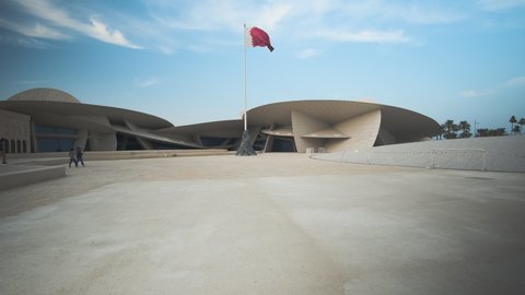 Doha, Qatar- December 20 2020 :National museum of Qatar interior zooming in afternoon shot showing the unique architecture of the museum , Qatar flag and visitors walking 