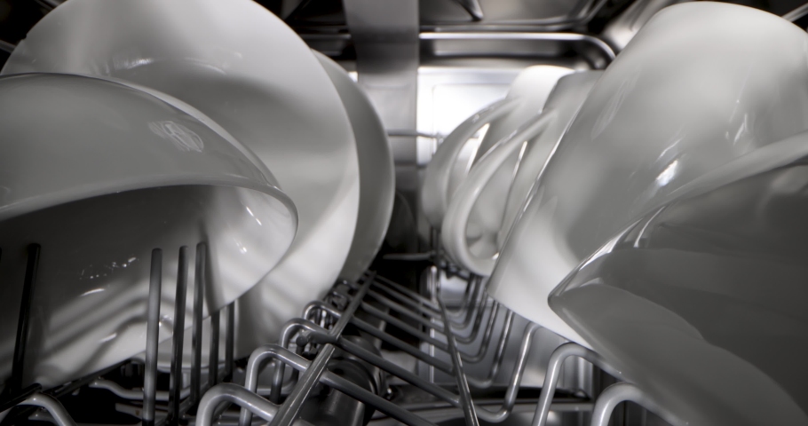 Household appliances - sliding inside dishwasher. rack with clean white dishware | Shutterstock HD Video #1065175507