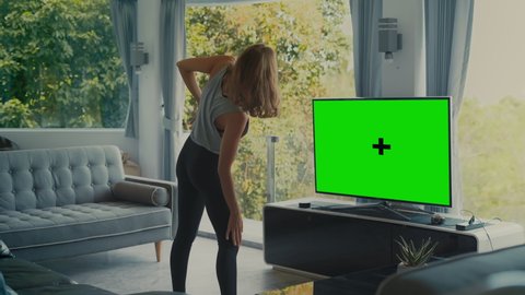 Fit girl doying yoga fitness work out infront of green screen TV in living room