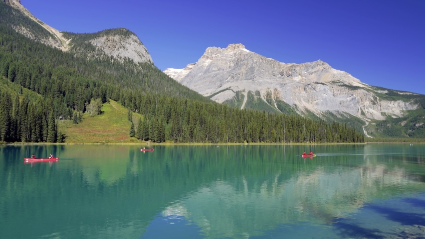 Canoeing on Emerald Lake in summer sunny day. Mount Burgess in the background. Yoho National Park, Canadian Rockies, British Columbia, Canada.