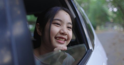 Cinematic Pretty Asian Girl In Car, Leans Out Passenger Side Car Window. Opens Window To Breathe Fresh Air Of Countryside.