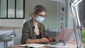 Office worker wearing surgical face mask in open space area