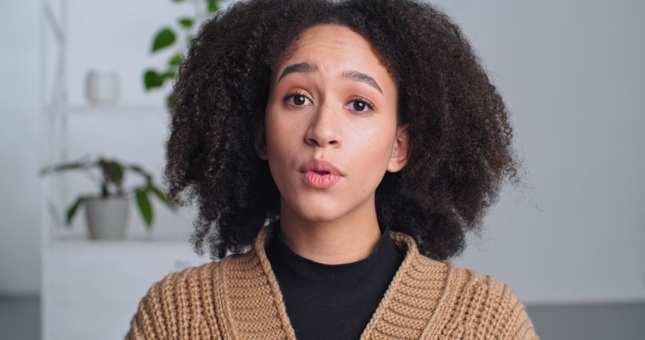 Cute sly african american black woman folds her hands in request pleading makes gesture of apology asks for forgiveness grimaces face expresses pity, emotional lady female face looking at camera