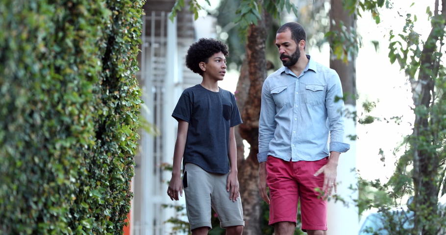 Parent and child walking together. Father giving advice to son, dad and kid bonding