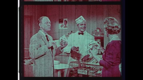 1950s USA Drive-in Movie Theater Intermission Announcement. Soda Jerk serves Customers Pop Corn, Hot Dogs and Soft Drinks during Intermission at Movie Theater. 4K Overscan of Archival 16mm Film Print