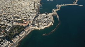 Molfetta, Apulia, Italy.Beautiful panoramic aerial 4K video from flying drone to Molfetta beach and Old Town skyline and views of the harbor. A tourist resort in southern Italy at sunrise.(Series)