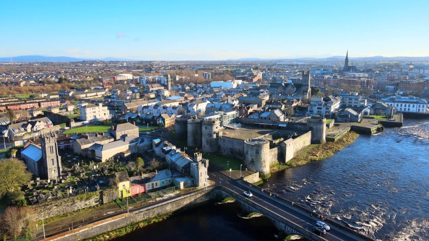 Aerial view over Limerick City in Republic of Ireland. There are number of eye-catching landmarks in Limerick such as Thomond Bridge,  King John's Castle, St. Mary's Cathedral and River Shannon. Royalty-Free Stock Footage #1065211903