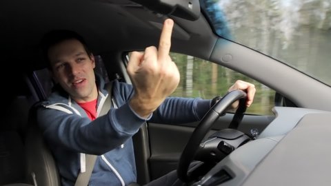 Drunken aggressive man shows middle finger fuck off while driving car