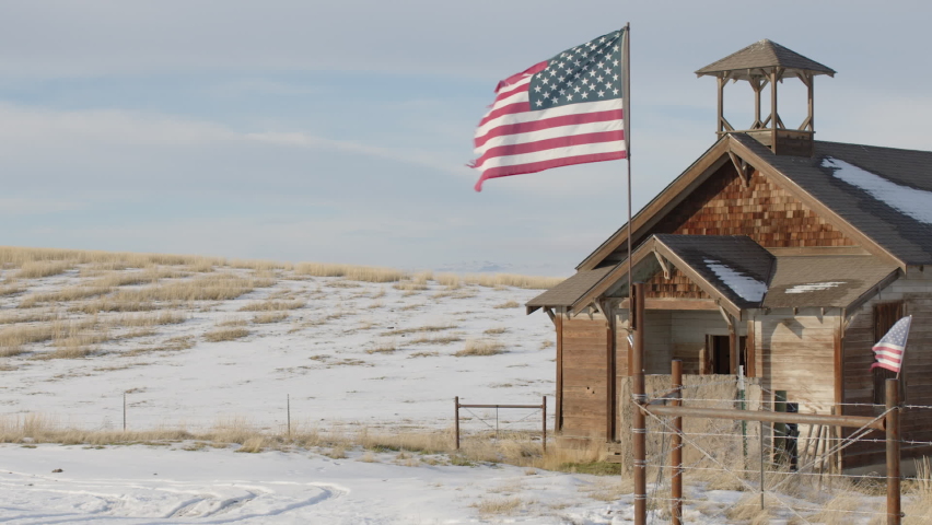 Abandoned Snowy School House with Tattered America Flags - Shallow DOF