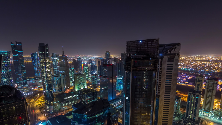 The skyline of the West Bay area from top in Doha timelapse, Qatar. Illuminated modern skyscrapers aerial view from rooftop at night