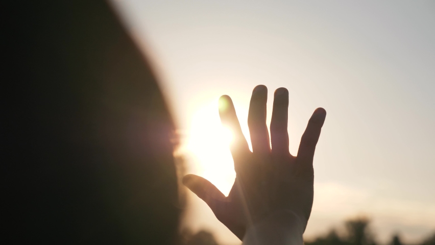 Hand of happy girl at sunset. Sunset between the hands of girl. Happy girl with long hair dreamily stretches out her hand to the sun. Child's dream hand to the sun. happy family concept Royalty-Free Stock Footage #1065225805