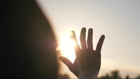 Hand of happy girl at sunset. Sunset between the hands of girl. Happy girl with long hair dreamily stretches out her hand to the sun. Child's dream hand to the sun. happy family concept - Powered by Shutterstock - Get 15% off with code: PIKWIZARD15
