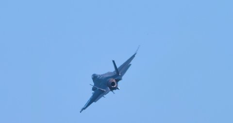 Modern grey stealt military jet aircraft does a vertical climb with full afterburner in blue sky. Lockheed Martin F-35 Lightning high performance demonstration. Ravenna Airshow June 23th 2019