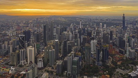 Kuala Lumpur Time lapse: Aerial view during dusk overlooking KL skyline and busy city streets from afar at sunset in Malaysia. Cinematic. Golden hour. 