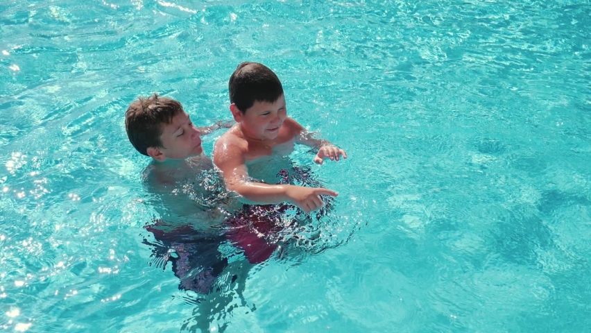 Cheerful kids relaxing during summer vacation in the pool slow motion | Shutterstock HD Video #1065228742
