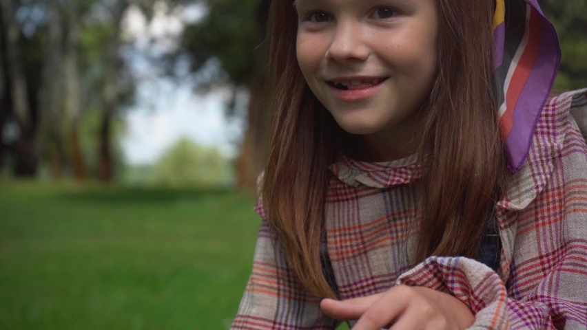 happy child playing with water stream on green lawn