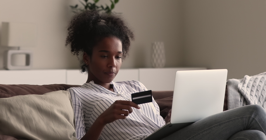 Young African woman due insufficient funds experiencing problems during payment online with credit card, use laptop try to pay for services on internet unsuccessfully. Blocked card, scam fraud concept Royalty-Free Stock Footage #1065237340