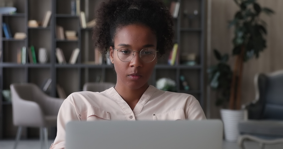 African young 25s woman sit at desk use laptop working long time on electronic device feels tired takes off glasses reduce eye strain. Harmful impact, technology negative effect on eyes health concept Royalty-Free Stock Footage #1065238147