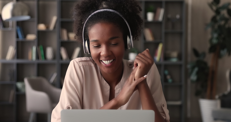 African student communicates with mate by video call app on laptop, woman wear wireless headphones talk to friend remotely using modern tech and video conference application, videocall event concept Royalty-Free Stock Footage #1065238249