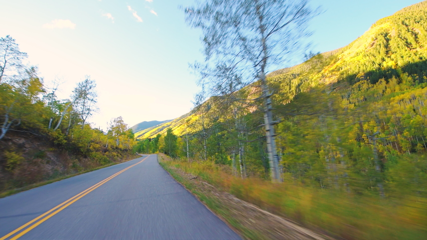 Pov point of view driving in car vehicle at Colorado USA Rocky mountains road trip with foliage in autumn fall on trees on Castle Creek scenic winding road with colorful yellow orange aspen leaves Royalty-Free Stock Footage #1065255961
