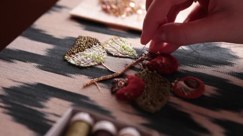 
The embroiderer at work. Couture embroidery of floral motifs