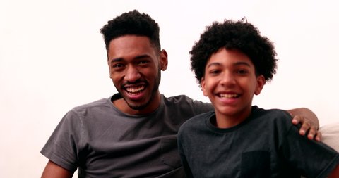 Two brothers together smiling. Black mixed race siblings, older and younger brother