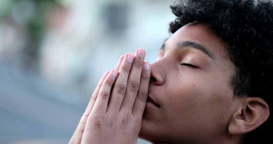 Young boy praying to God. Religious Mixed race child looking at sky with HOPE and FAITH | Shutterstock HD Video #1065276622