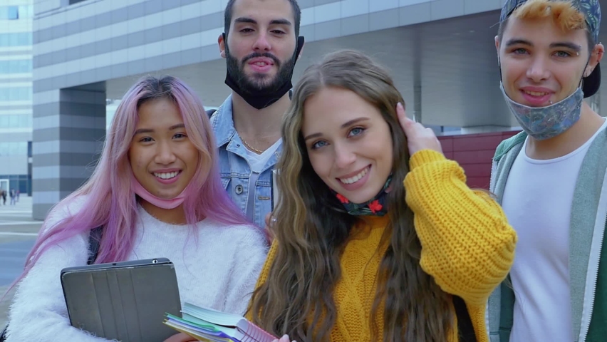 Cinematic footage of four students making activities outdoor after school. Multiethnic group of teenagers having fun together
