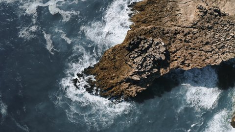 ocean waves hit the rock, rotating topshot aerial view in Portugal. High quality 4k footage