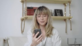 Young caucasian blonde woman talking on video call. Medium shot