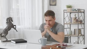 Man working from home online with laptop computer in home office.