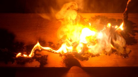 Lichtenberg Fractal Wood Burning. A fire is burning from a short circuit on a wooden board in a carpenter's workshop