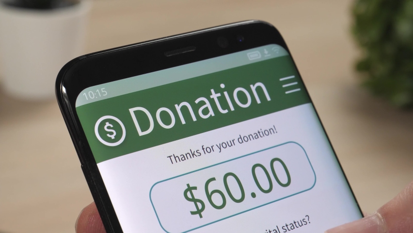 Making an online donation to a charity using a smartphone app. Royalty-Free Stock Footage #1065301966
