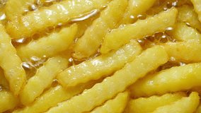 Tasty French-fries cooking in boiling oil. 4K UHD video.