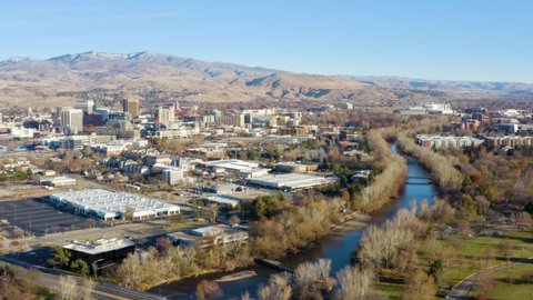 Drone flies over the Boise River in Boise, Idaho with the city in the background.
