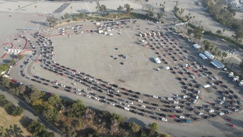 Covid testing aerial at a parking lot, tracking backwards to reveal to dodger Stadium