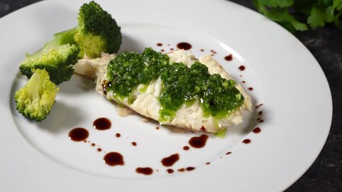 Prepared halibut fillet rich of healthy omega fat beeing served in white plate