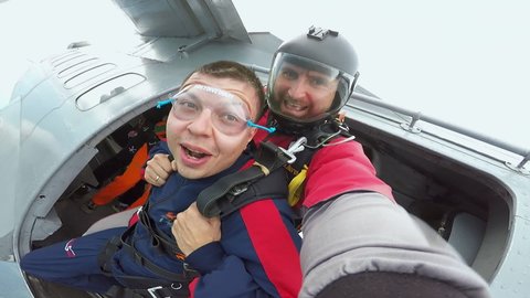 Russia. Tanay 18-23 August 2020: Parachute Weekend on Tanay: Parachutists Jump Out of Airplane at Great Height. Parachuting. Tandem. Selfie. First Leap in Life. Fall. Emotions. Fear. Signs with Hands