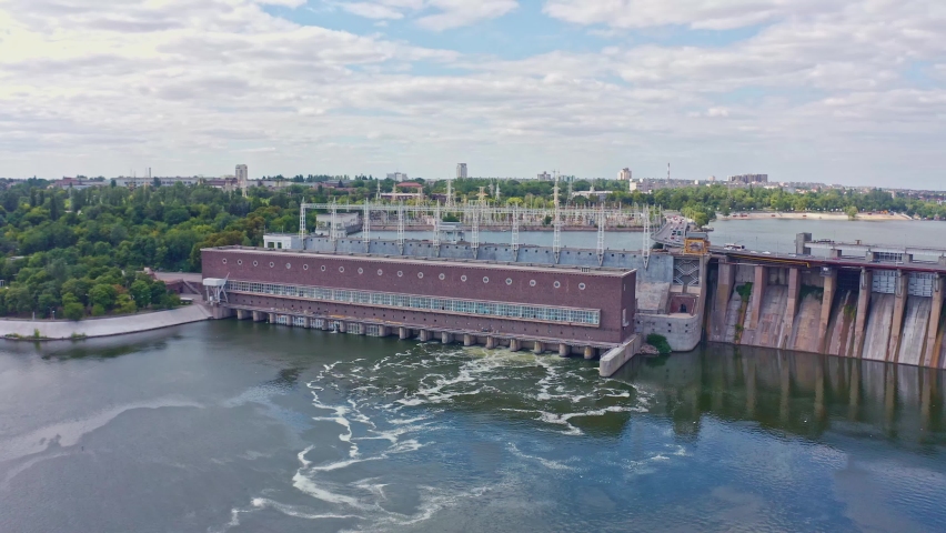 The beautiful river is surrounded by green and fresh vegetation in the city. Dnieper hydroelectric power station in Zaporozhye